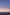 A flock of pelicans flying over the coastal ocean in a darkening sky